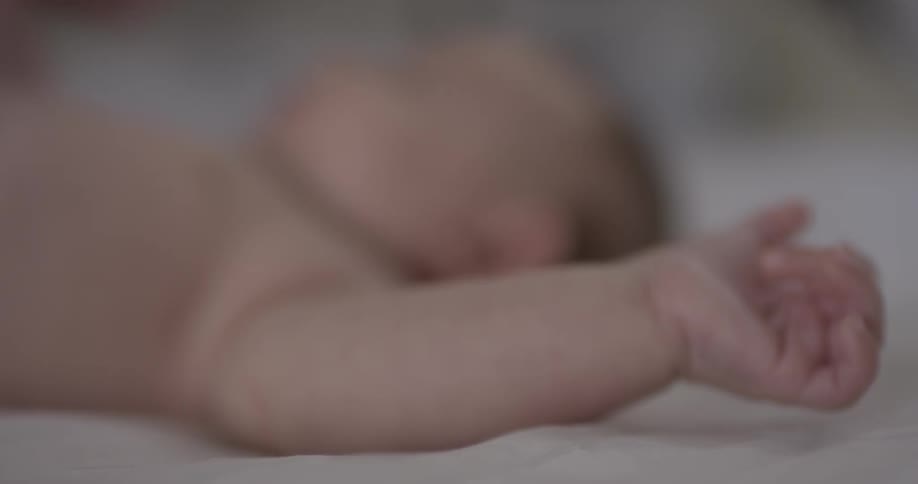 A baby laying on its back moves its arms around
