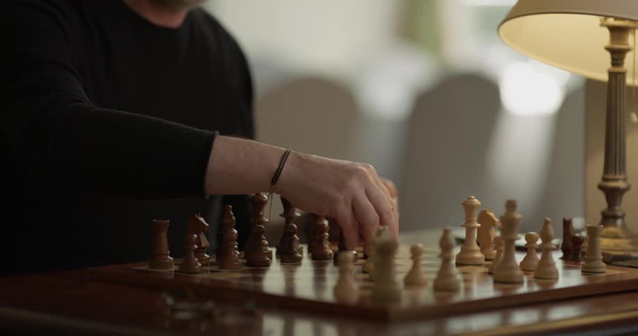 A man moves a chess piece