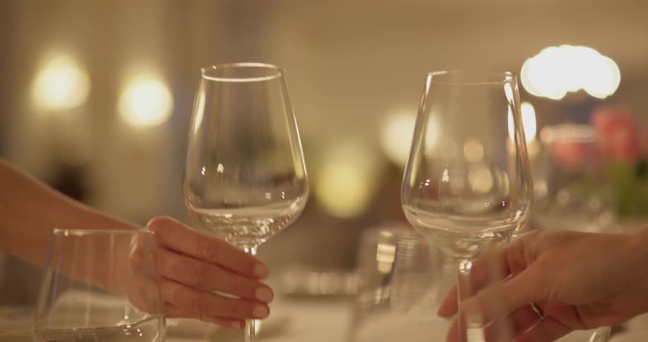 A person putting wine glasses down on a table