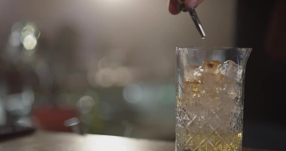 A man is pouring liquid into a glass of ice
