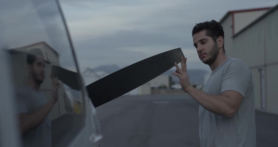 A man walks around a plane touching it as he inspects it