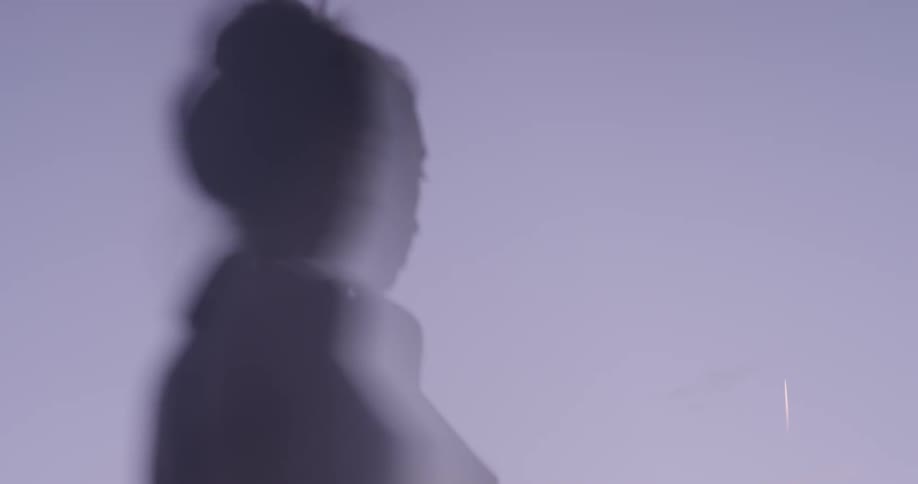 A shadow of a woman appears on a white background