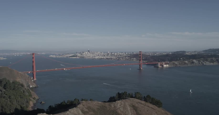 Long red bridge spans wide blue water