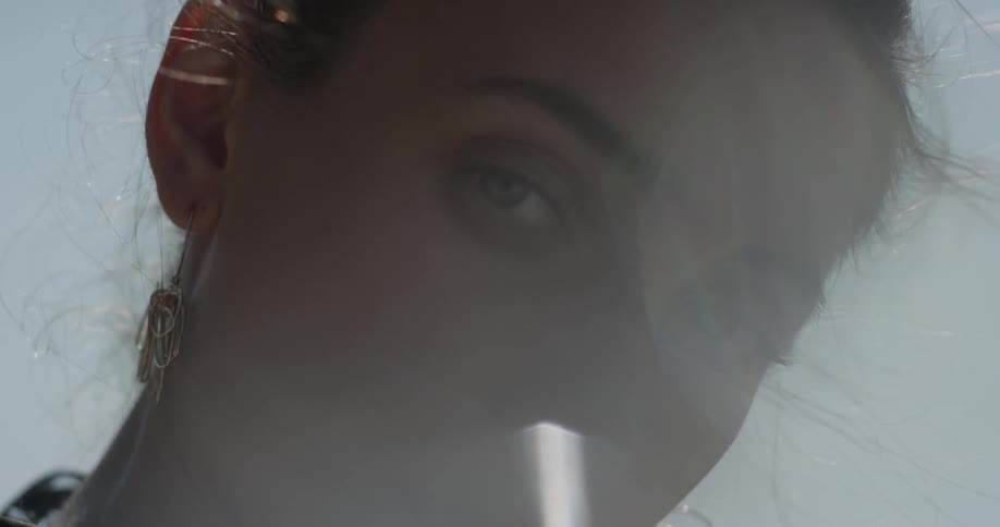 Glare of the sun behind a woman staring at the camera