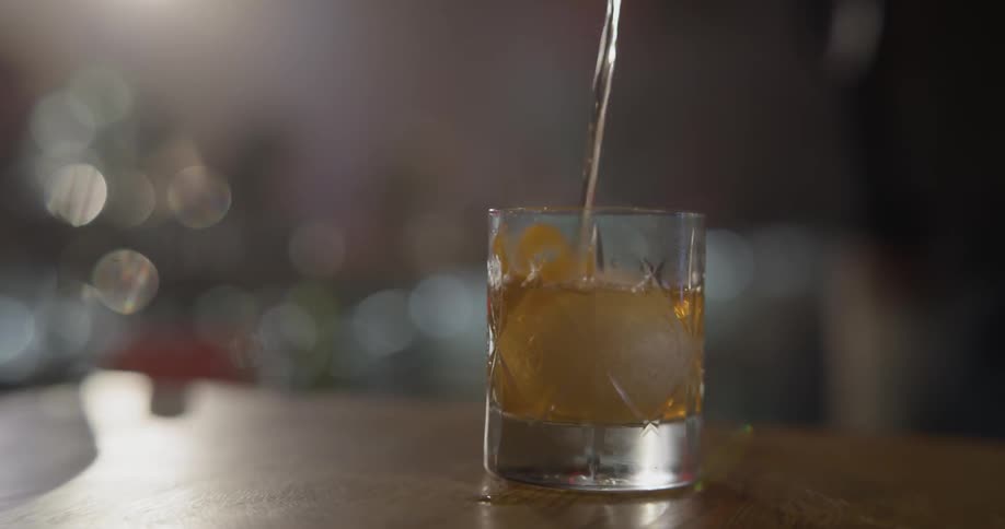 A glass of ice is filled with alcohol