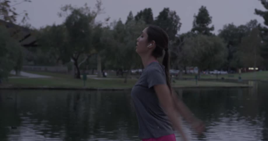 A woman stretches as she walks