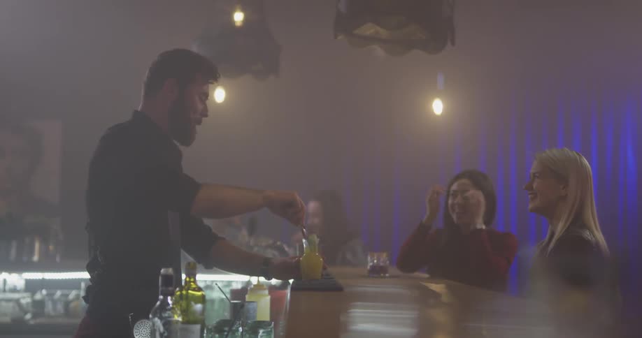 A bartender is making people drinks at a bar