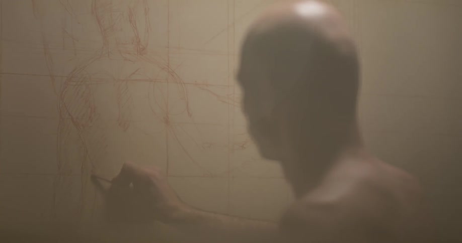 Man sketching on a board on the wall