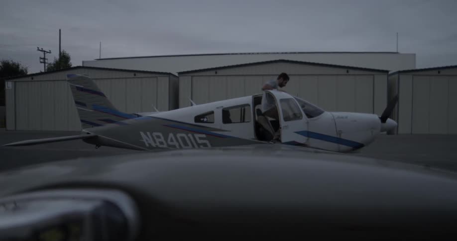 Man climbs into small airplane at airport