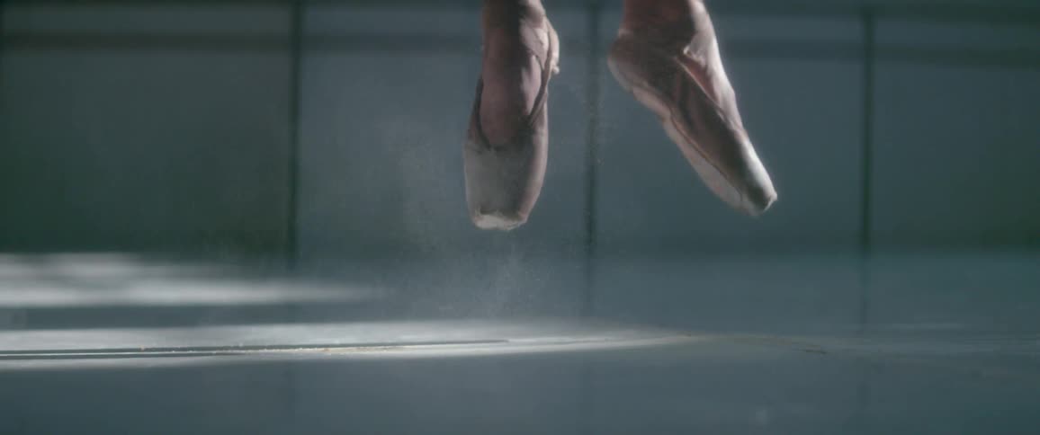Close up of a ballerina's feet as she jumps, spins and lands