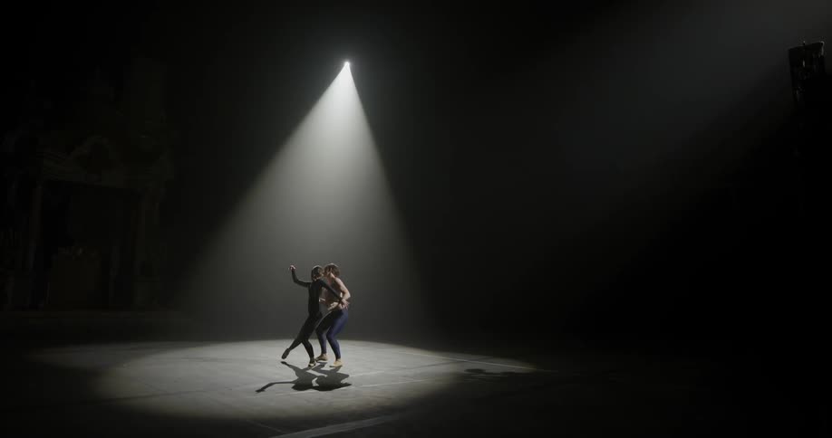 A man and woman dance in the spotlight