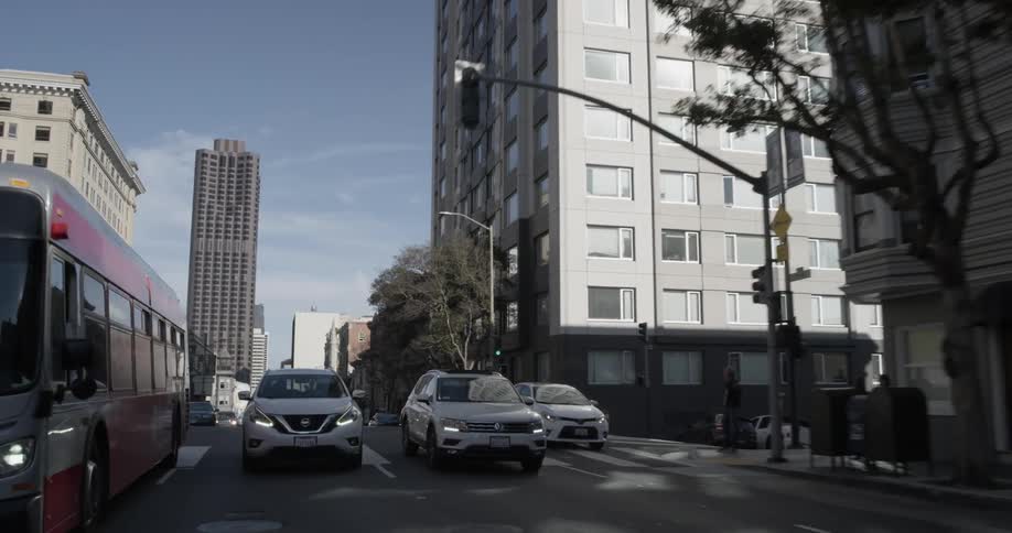 Cars move along a busy city road