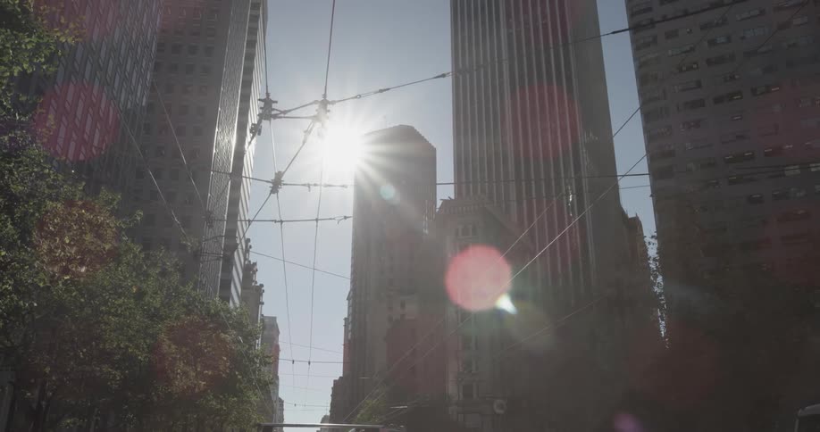 Sun shines beyond city skyscrapers