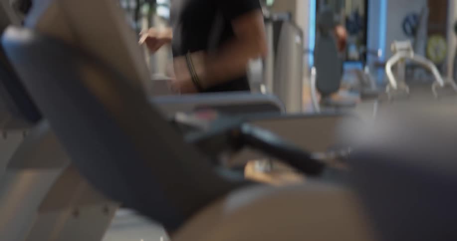 Man in health club jogs on treadmill