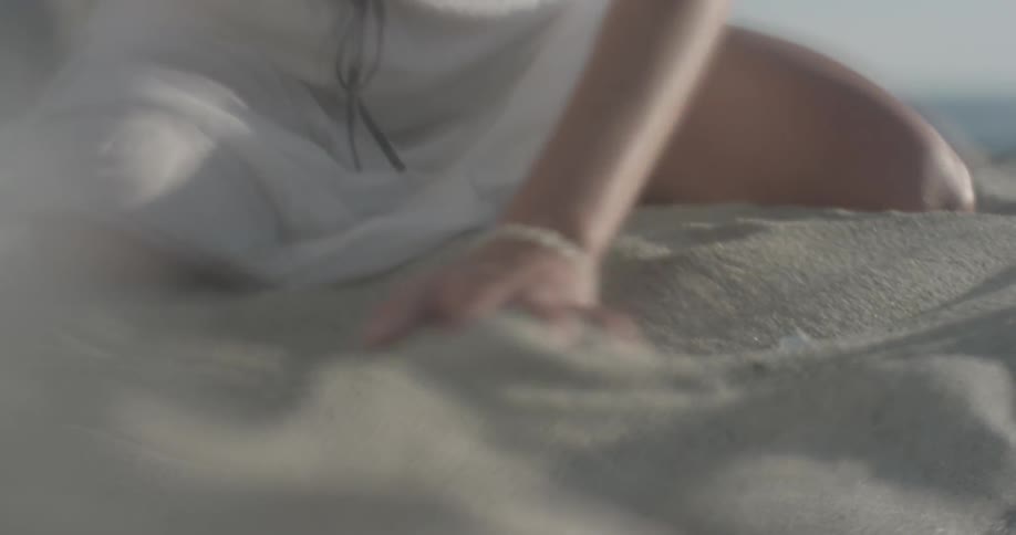 Woman plays in the sand on a sunny day