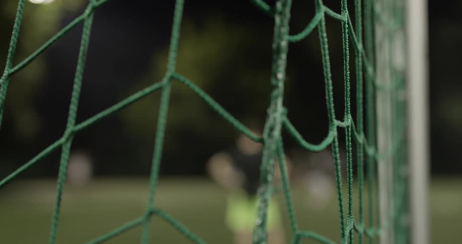 Two teams of boys play soccer on a field