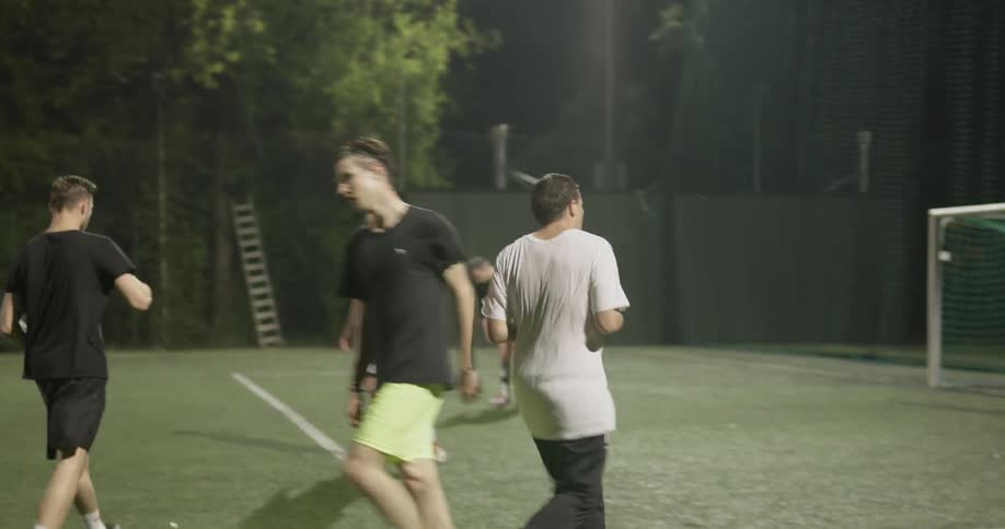 People playing soccer outdoors at night