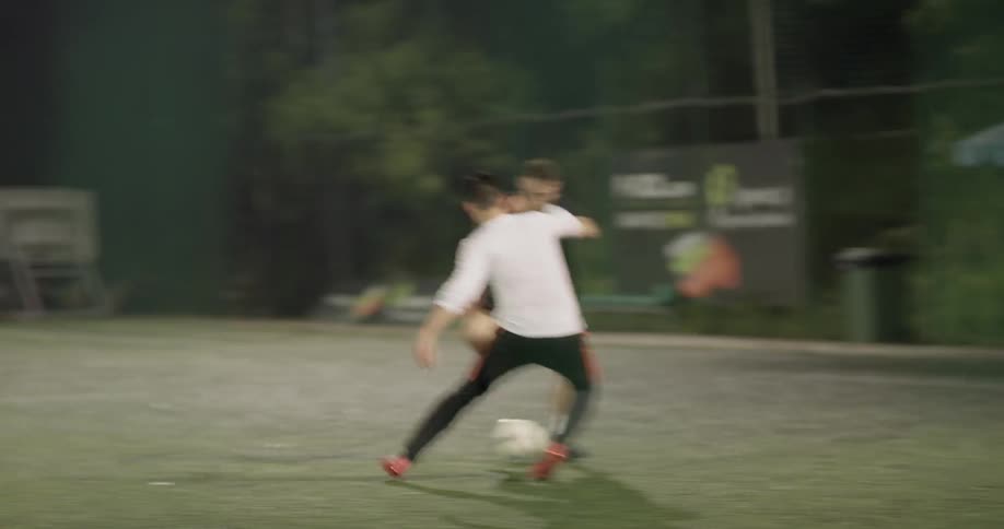 Group of men are playing soccer on field at night