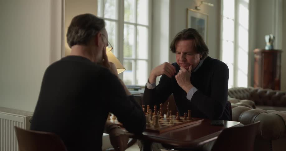 Two men sit down and play chess at noon
