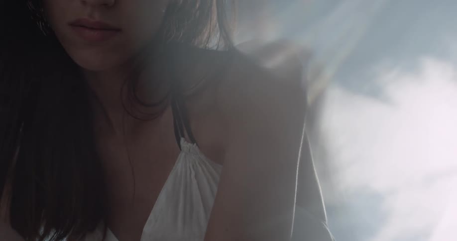 A woman kneels under the bright sun