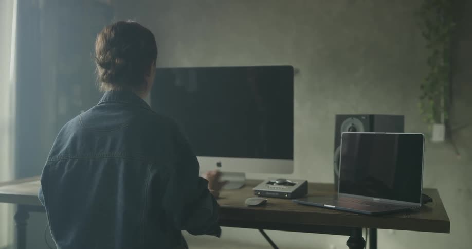 Woman at desk with computer typing on keyboard