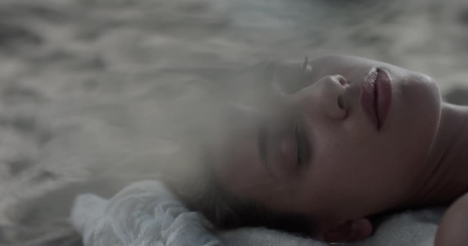 A woman laying on a blanket on the beach