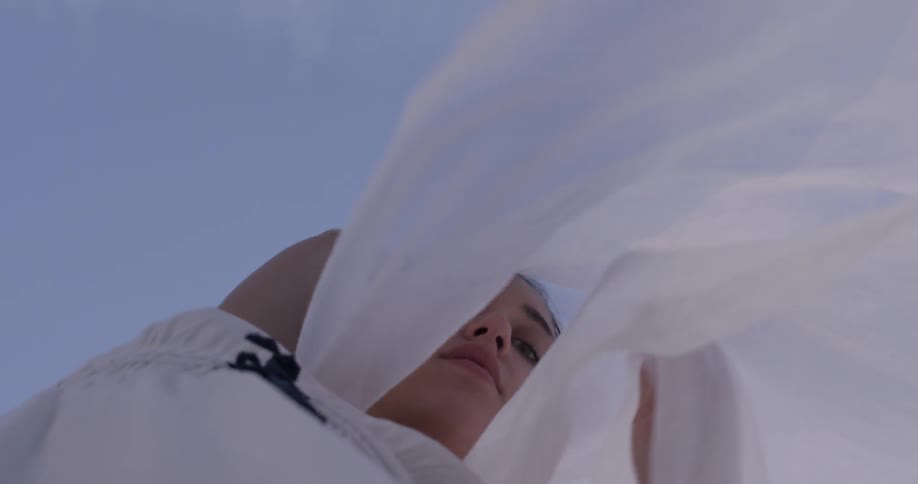 Woman dances with a piece of fabric while looking down