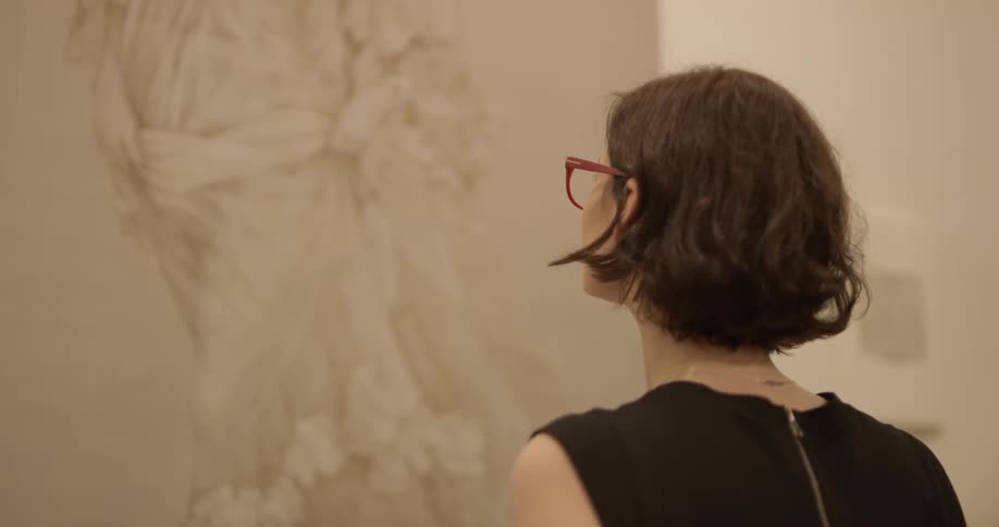 A woman is looking at a painting