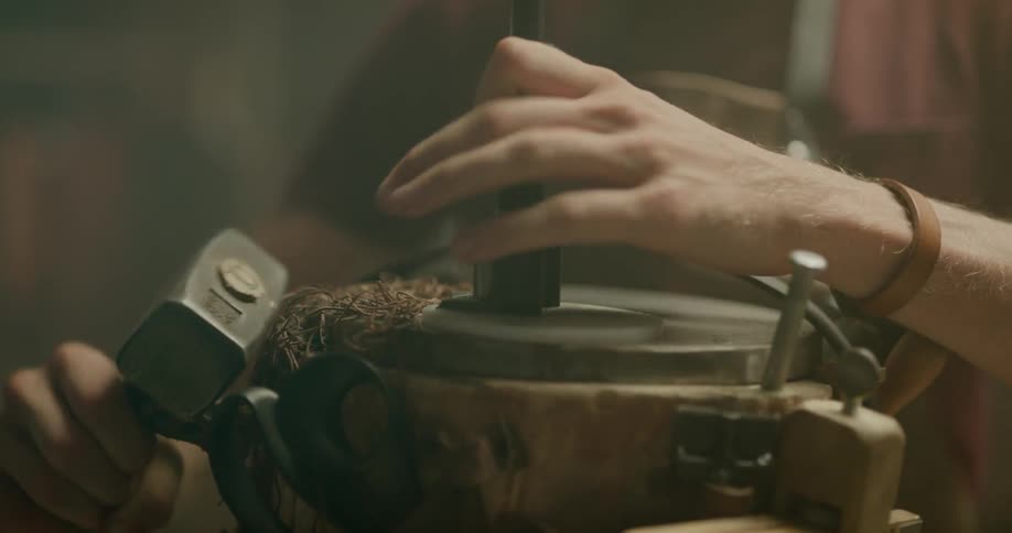A man is using tools to cut leather