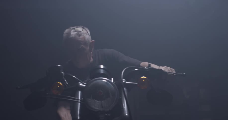 A man gets on a motorcycle