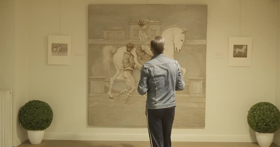 A man walking up to a large picture of women with a horse