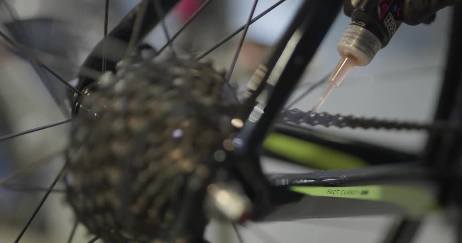 A man greasing the chains of a bicycle