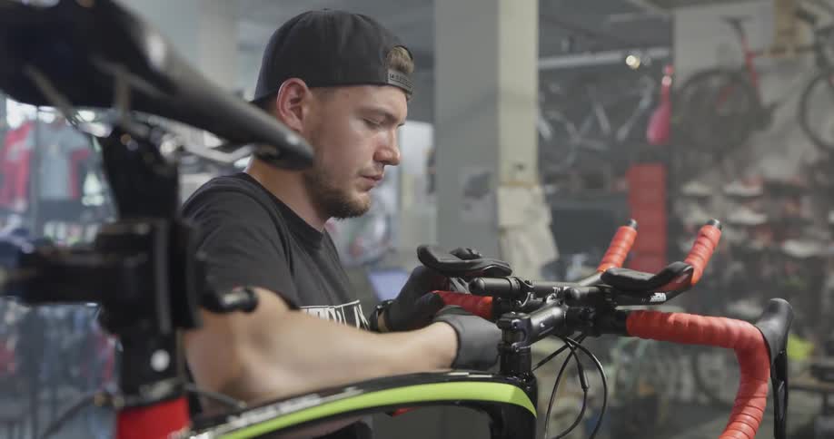 Young man adjusting the handlebars on a bicycle