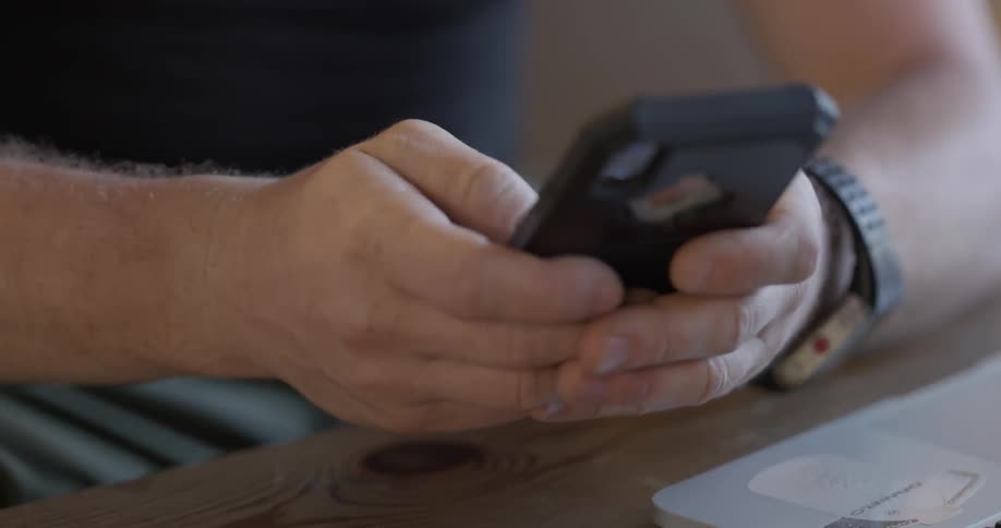 Man concentrating on his cell phone in his hands