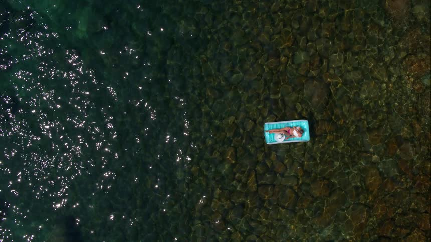 A woman floating on a raft in a large body of water