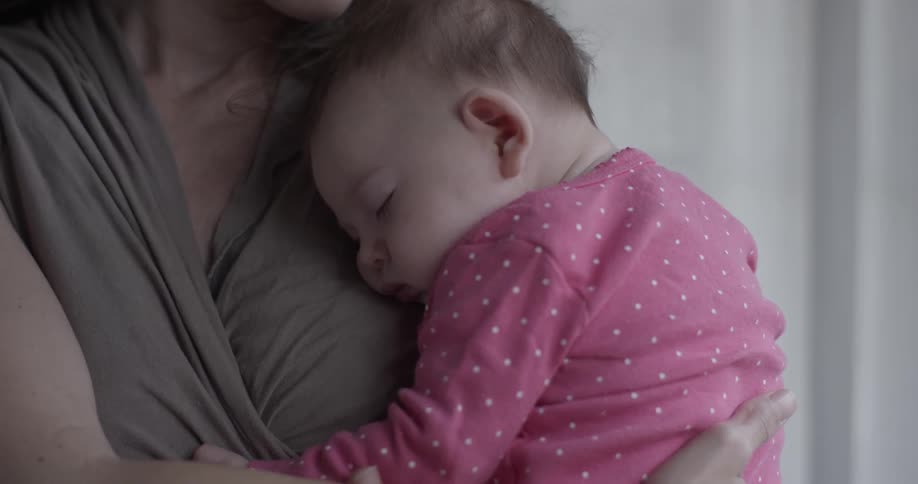 A woman holds a baby to her chest