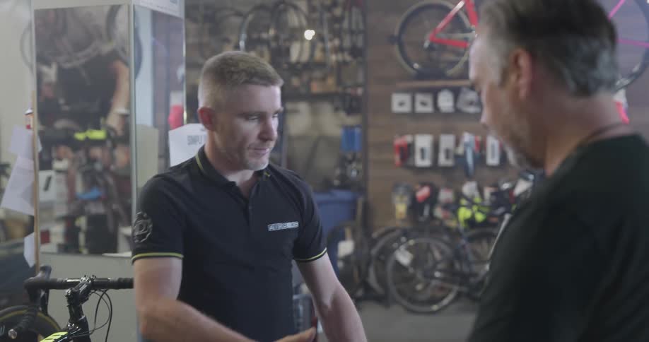 A bicycle shop employee helps a customer