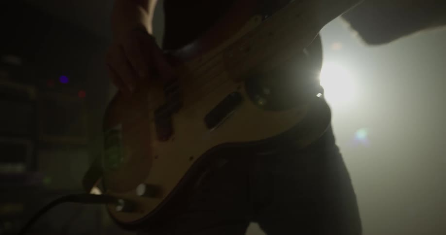 Man dances around as he plays an electric guitar