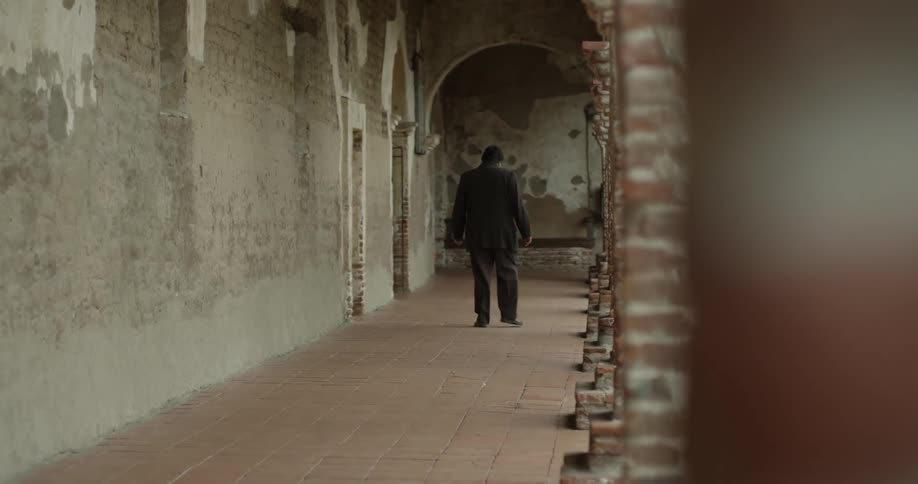 Man walking outside of a building in a walkway