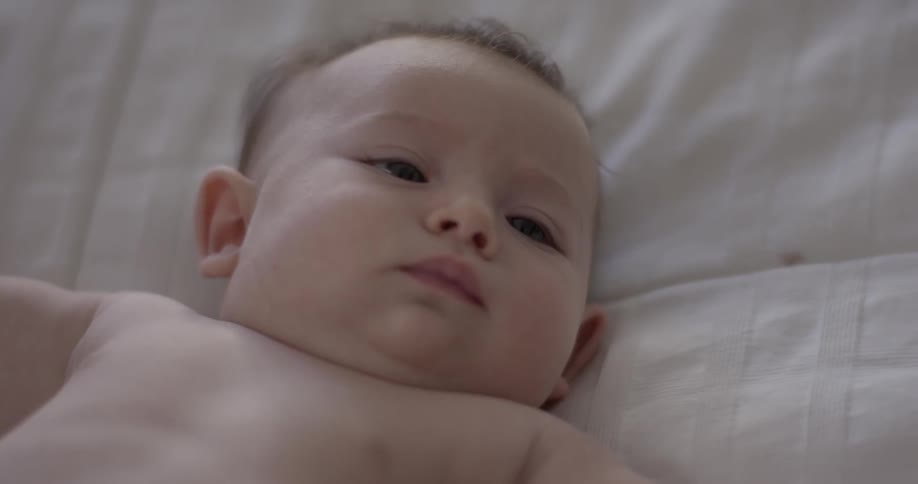 Baby lays on back and looks up
