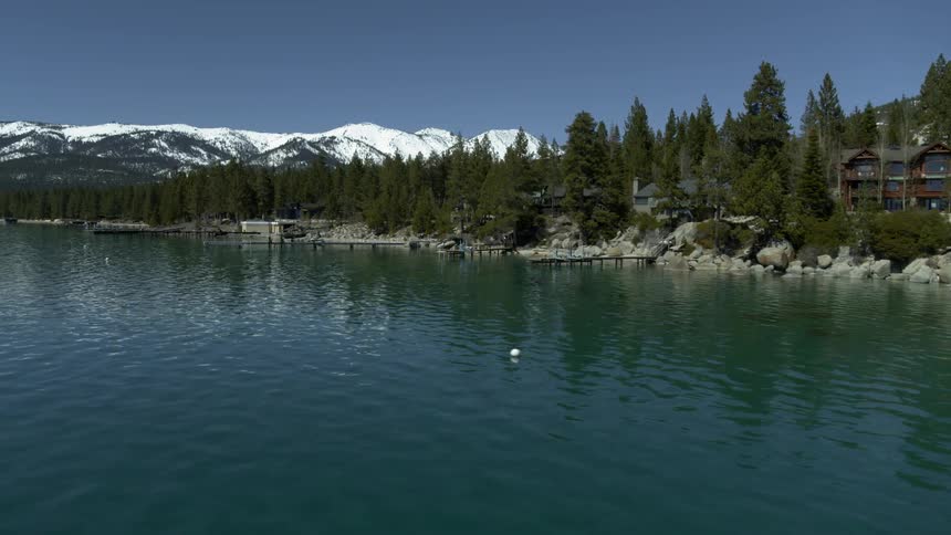 Snow covered mountains surround a clear body of water