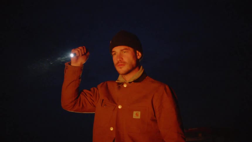 Man with a flashlight looking for something in the distance