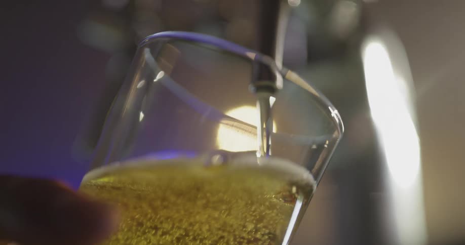 A beer glass is being filled from a tap