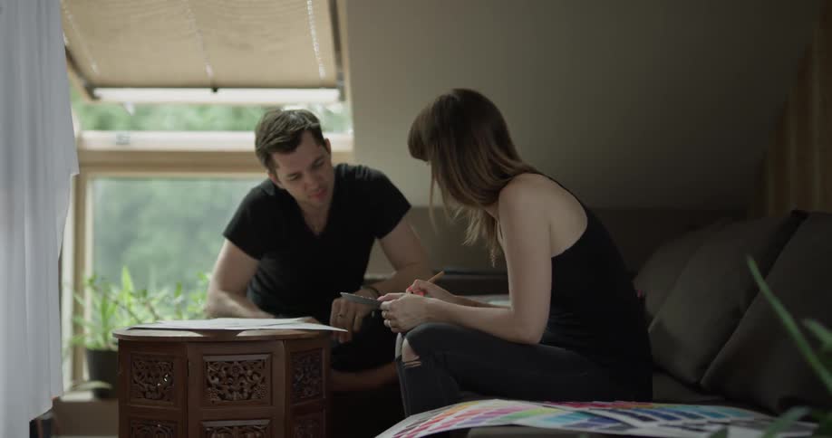 A man and woman discuss different papers