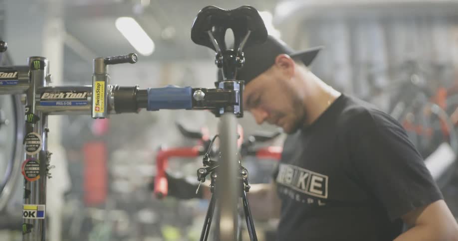 Man examines bicycle as he cranks pedal