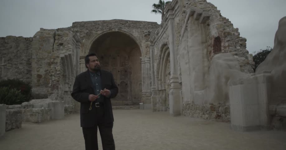A man walking down a gravel path in front of a church