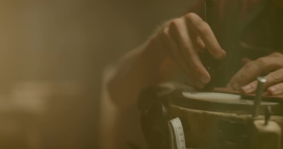 A man is using tools to cut leather