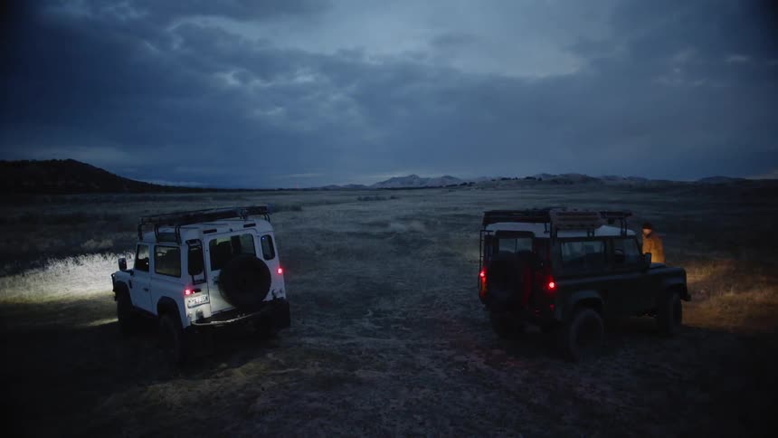 Two vehicles parked off road with people getting out of them