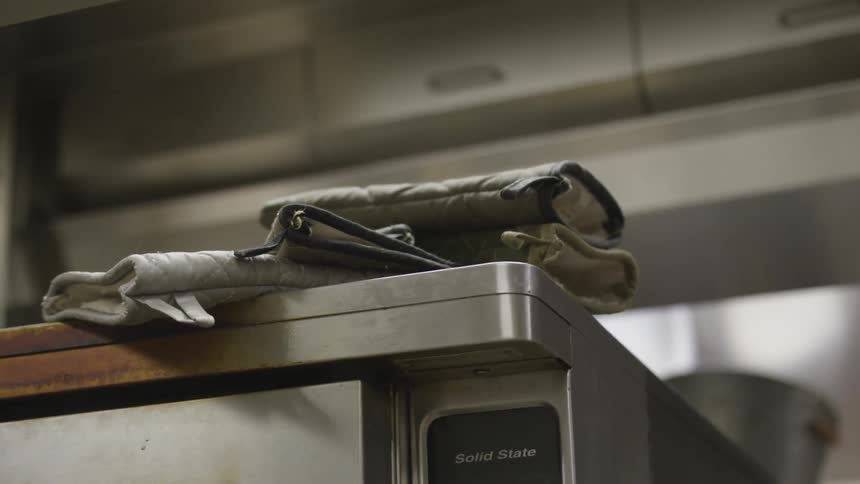 There are oven gloves on the counter
