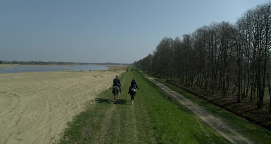 Two people are riding horses outside
